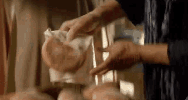 a person is holding a piece of meat in their hands .