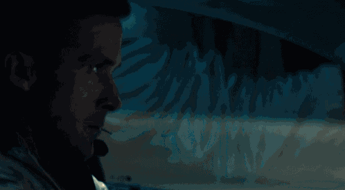 a man smoking a cigarette while driving a car at night
