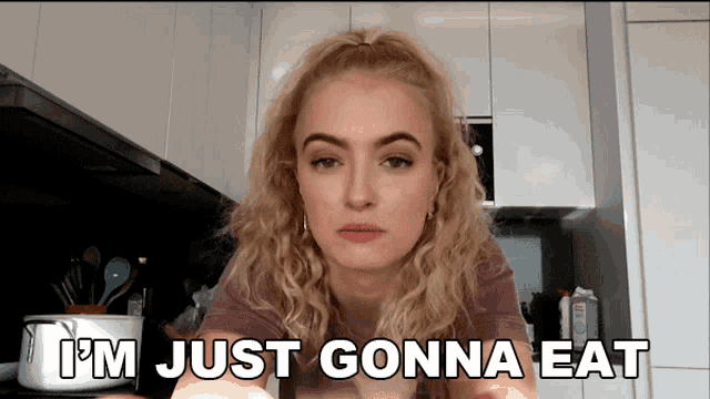 a woman in a kitchen with the words i 'm just gonna eat behind her