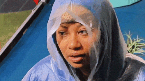 a woman wearing a blue raincoat with a clear plastic hood