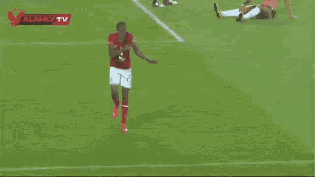 a group of soccer players on a field with alahly tv on the bottom