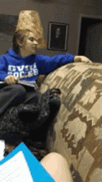 a person wearing a blue sweatshirt that says gvw college is sitting on a couch
