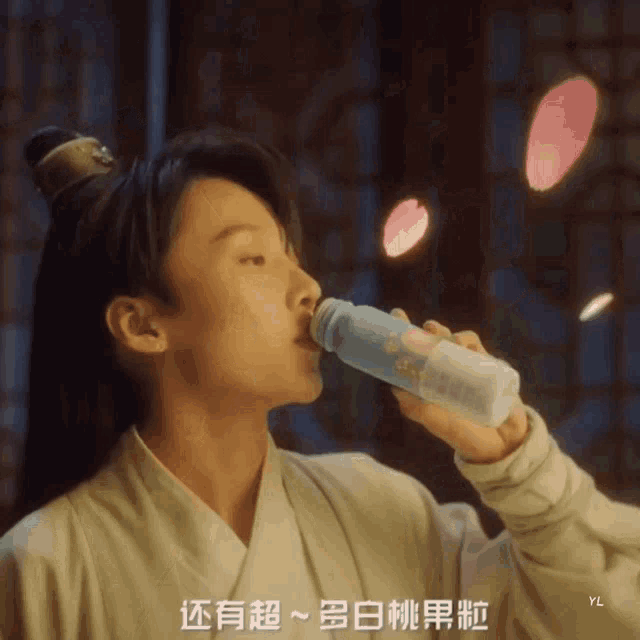 a man drinking from a bottle with chinese writing on the bottom