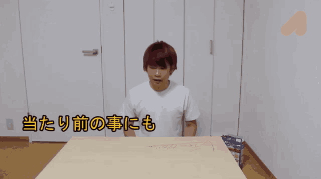 a man with red hair is sitting at a table with chinese writing