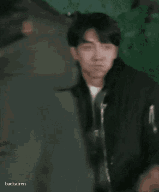 a man in a black jacket with the name baekairen on the bottom right corner