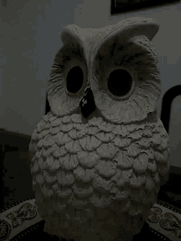 a statue of an owl sitting on a chair