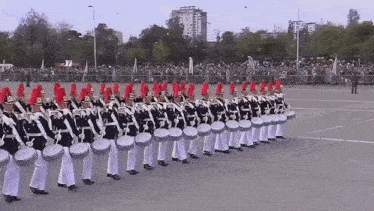 a military marching band is marching down a street