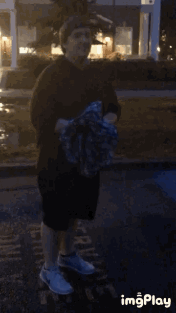 a person holding a blue umbrella in the rain with imgplay written on the bottom