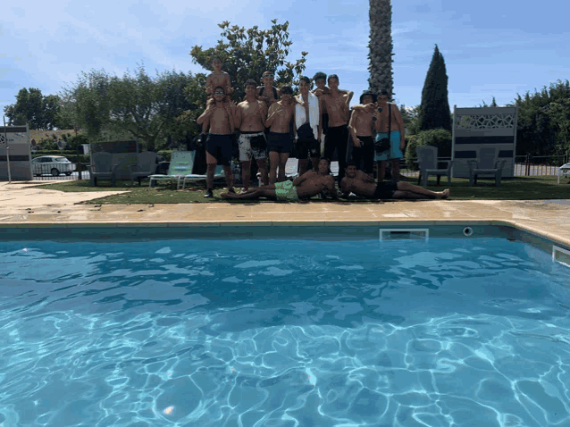 a group of young men are posing for a picture by a pool