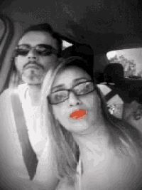 a man and a woman are in a car and the woman has red lips