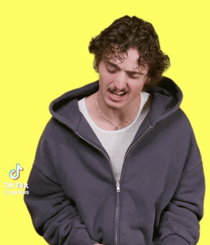 a man wearing a grey hoodie and a white shirt has a tiktok sticker on his face