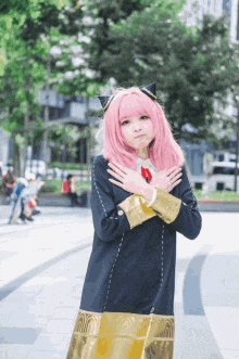 a girl with pink hair and cat ears is wearing a black and gold outfit