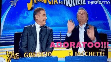 two men sitting on a stage with the words adoratoo written in pink