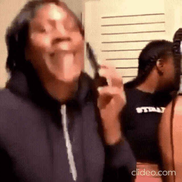 a woman is making a funny face while holding a pair of scissors in her hand .