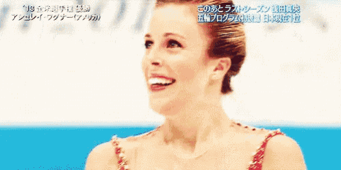 a woman in a red dress is smiling in front of a sign that says " 19 "
