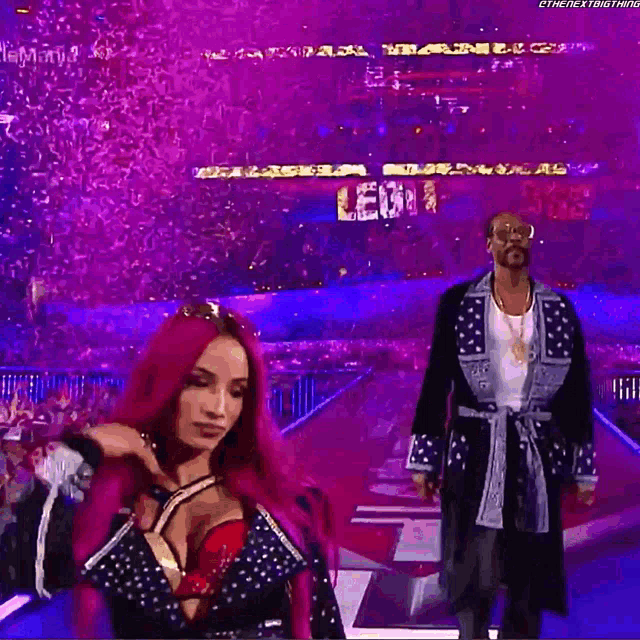 snoop dogg and sasha banks are dancing in front of a crowd