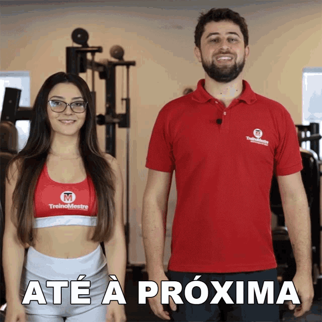 a man and a woman are standing next to each other and the woman is wearing a red shirt that says treino mestre