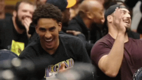 a man wearing a legend shirt is laughing in the stands