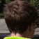 the back of a person 's head with a yellow shirt on .
