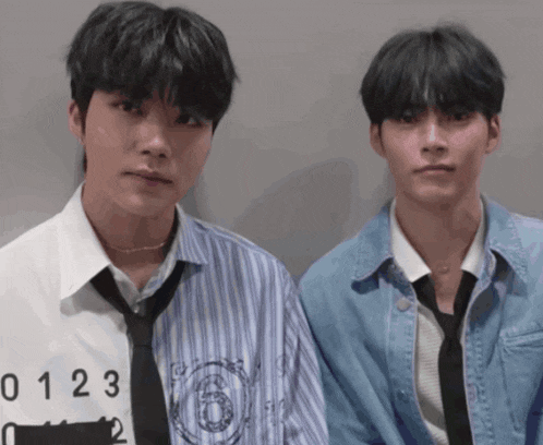 two young men are standing next to each other with one wearing a shirt with the number 0123 on it