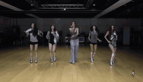 a group of women are dancing together in a room