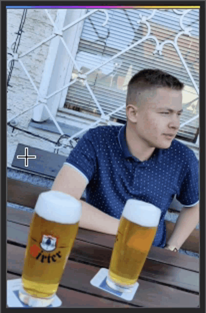 a man sits at a table with two glasses of beer on a coaster that says fritz