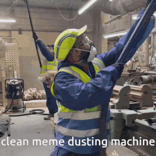 a man wearing a mask and safety vest is cleaning a machine with the words clean meme dusting machine below him