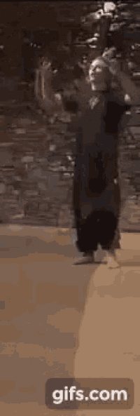a person is standing in a room with a brick wall in the background .