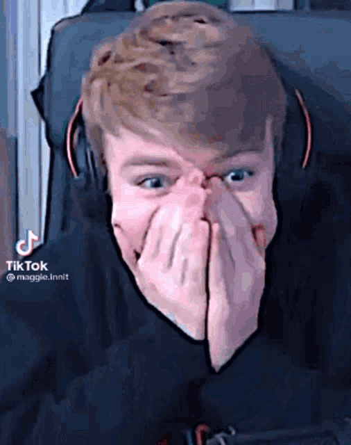 a man with headphones is covering his face with his hands .