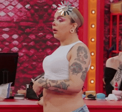 a woman with tattoos on her arms is wearing a white crop top and shorts .