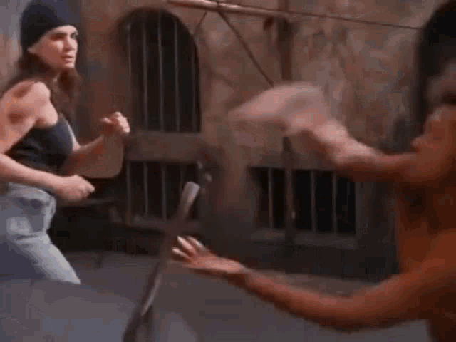 a man and a woman are standing next to each other and fighting .