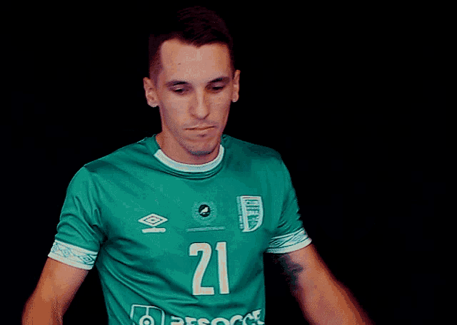 a man wearing a green shirt with the number 21
