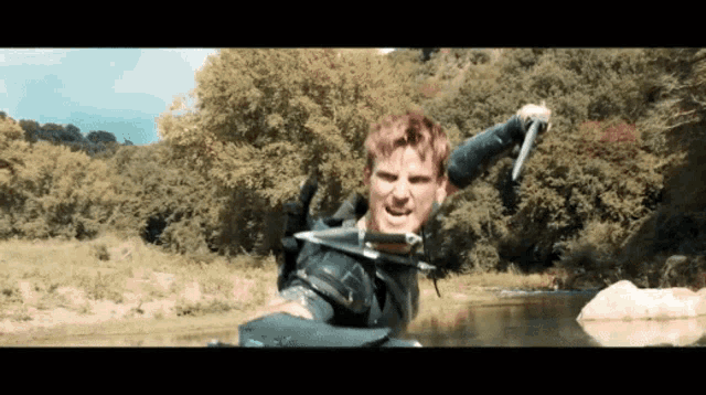 a man is holding a knife and screaming in a river