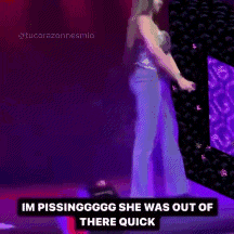a woman is standing on a stage with a purple background and a caption that says im pissinggggg she was out of there quick