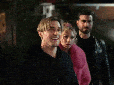 two men and a woman are standing next to each other