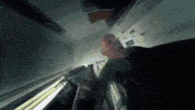 a man is standing in a dark room looking up at the ceiling