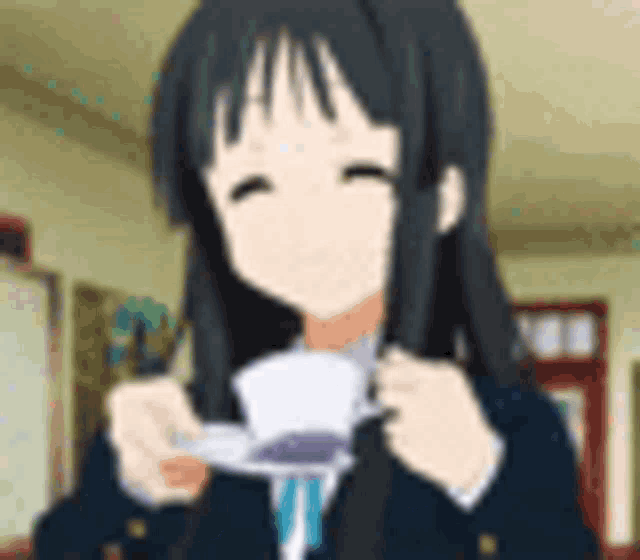 a girl with long black hair is holding a piece of paper in her hands .
