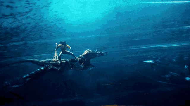 a man is riding on the back of a dragon in the ocean