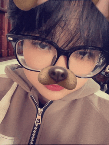 a girl wearing glasses and a dog mask has a zipper on her hoodie