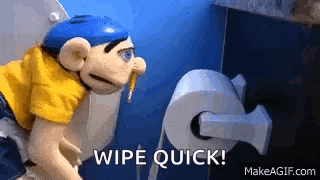 a puppet is sitting on a toilet next to a roll of toilet paper and saying `` wipe quick '' .