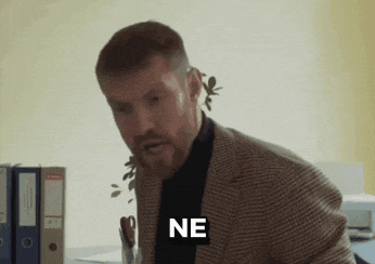 a man in a suit has the word ne written on his shirt