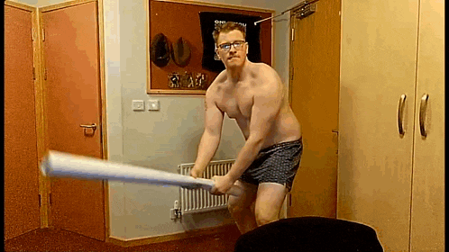 a shirtless man in underwear is swinging a bat