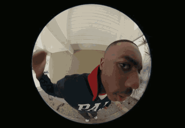 a fisheye view of a man wearing a sweatshirt that says da