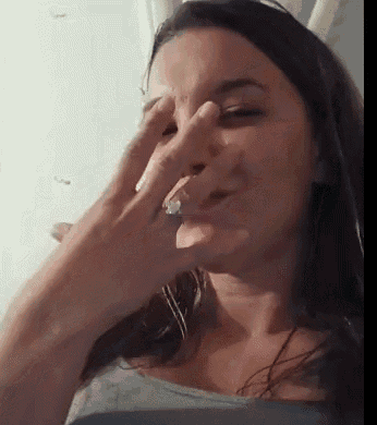 a woman is covering her nose with her hand while wearing a ring on her finger .