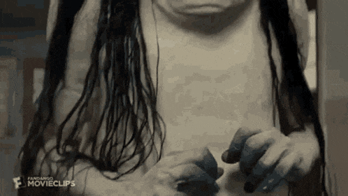 a black and white photo of a woman without a shirt holding something .