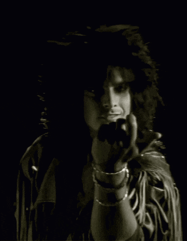 a black and white photo of a man in a leather jacket giving the middle finger