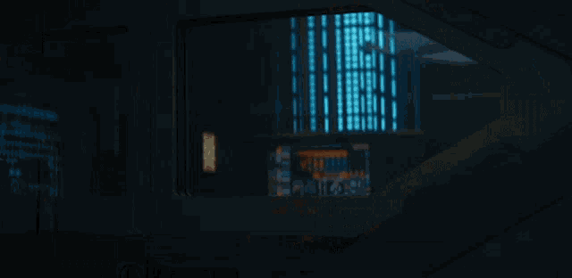 a man in a suit and tie is standing in front of a computer monitor .