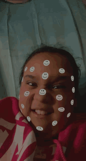a girl with smiley faces on her face