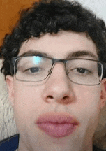 a close up of a man wearing glasses and making a funny face .