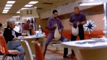 a man in purple pants is dancing in a bowling alley with a sign that says 22
